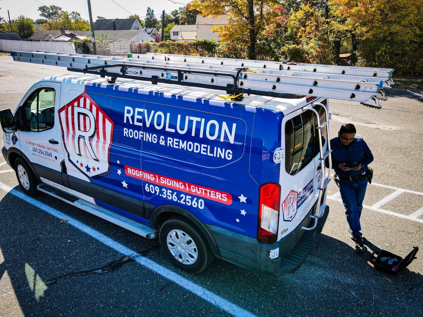 Revolution service van with ladders on the roof rack and a technician arriving for a free estimate